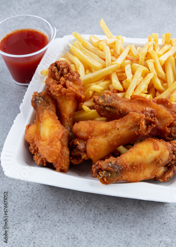 Chicken Wings with French Fries and sauce in Container