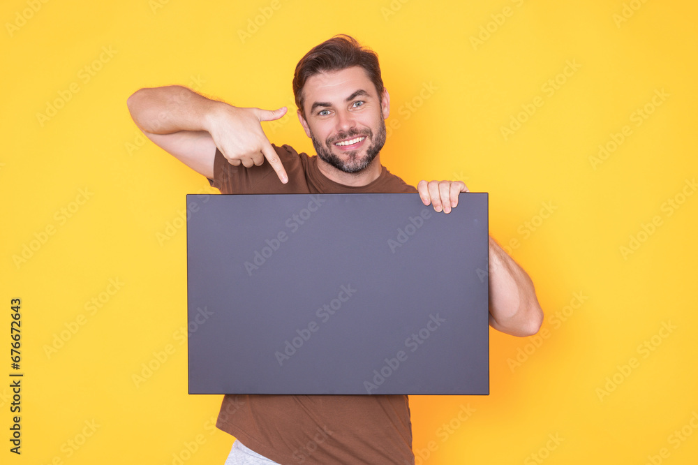 Man holds sign with copy space. Placard ready for copy space product. Sign to your copy space text. Man showing blank sign board on studio background, pointing finger. Empty copy space blank board. Man holds sign with copy space. Placard ready for copy space product. Sign to your copy space text. Man showing blank sign board on studio background, pointing finger. Empty copy space blank board.