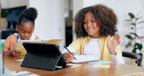 Children, e learning and tablet with writing, wave hello or book for education, development or study at desk. Kids, touchscreen and notebook with smile, online course and home school in family house © Charlize D/peopleimages.com