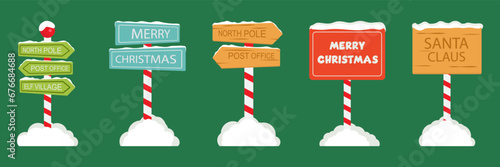 North Pole Signboards and Christmas Wooden Street Signs set in Snow, Winter Pointers with Garlands, Snow, and Striped Poles. Winter Holiday, Xmas Banners. Cartoon Vector Illustration