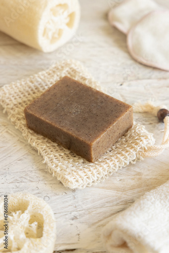 Brown handmade soap bar on soap saver bag  close up. Organic skincare products