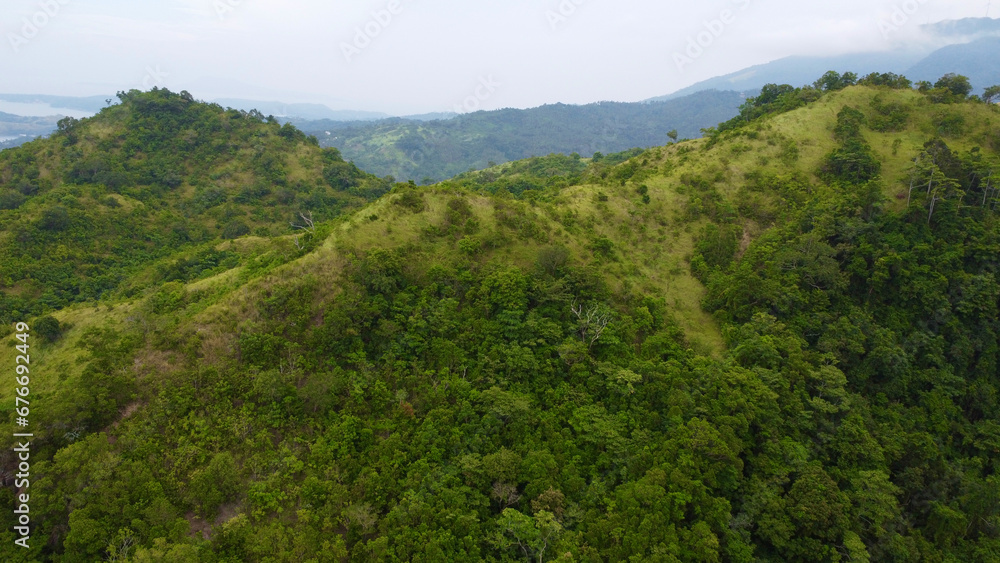 Forest in the mountains. Mountain range of a tropical island. Mountain tops covered with jungle. Aerial view of green hills and mountain peaks. Forest in the mountains. Mountain range of a tropical island. Mountain tops covered with jungle. Aerial view of green hills and mountain peaks.