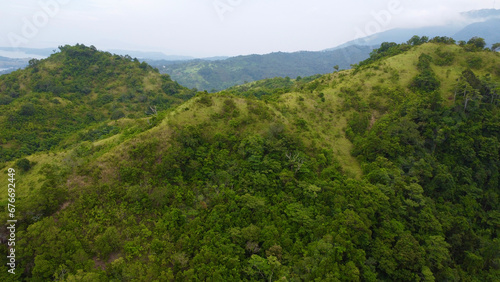 Forest in the mountains. Mountain range of a tropical island. Mountain tops covered with jungle. Aerial view of green hills and mountain peaks.