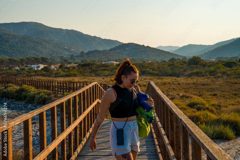 Girl walks on a wooden bridge to go to the sea