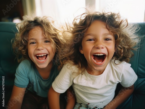 Dos niños jugando y gritando alegremente mientras miran a la camara photo