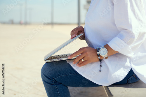 Details on female entrepreneur hands opening the laptop lid, ready to online working outdoors