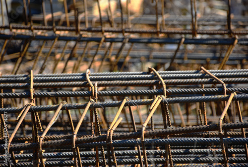 grey silver color steel rebar column reinforcement with stirrups. closeup abstract view. selective focus. blurred background. construction concept. building site. building industry. 