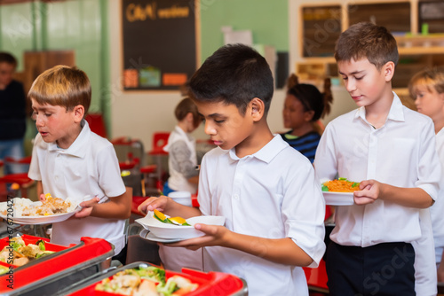 children eat in the school canteen. children stand in line for food in the cafeteria with trays. school nutrition concept photo