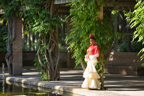 Wallpaper Mural Young black and South American woman in a beige gypsy flamenco suit and red shawl, posing in a park in the city of Seville in Spain. Concept dance, folklore, flamenco, art. Torontodigital.ca