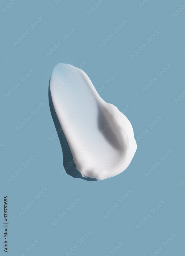 White cosmetic smear of cream texture on a blue background. Skin care. White cosmetic smear of cream texture on a blue background. Skin care.