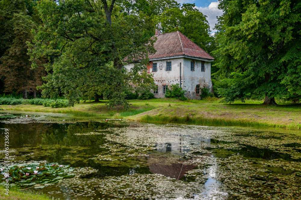 View of the hunting castle through the flower pond. Oldest buildings at the Pope Estate is the old hunting castle that was built in 1653. Latvia, Baltic. View of the hunting castle through the flower pond. Oldest buildings at the Pope Estate is the old hunting castle that was built in 1653. Latvia, Baltic.