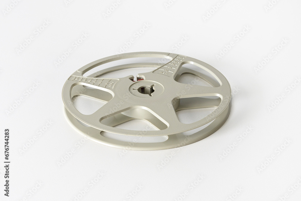 Empty reel to reel tape recorder or 8mm film reel. Cassette of a household film projector from the 60s-70s. White background, close-up