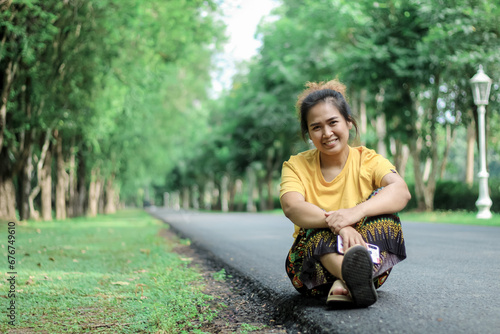 
Beautiful smiling Asian woman in the park green trees in spring nature background