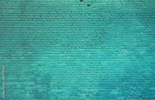 The texture of the brick wall of many rows of bricks painted in cyan color