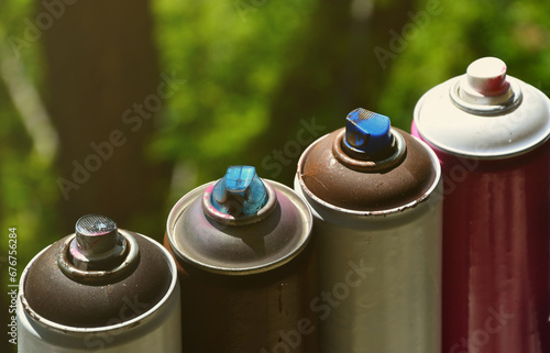 A few used aerosol paint sprayers lie on the windowsill in the workshop of a graffiti artist. The concept of street art and illegal drawing on the walls. Youth hobby