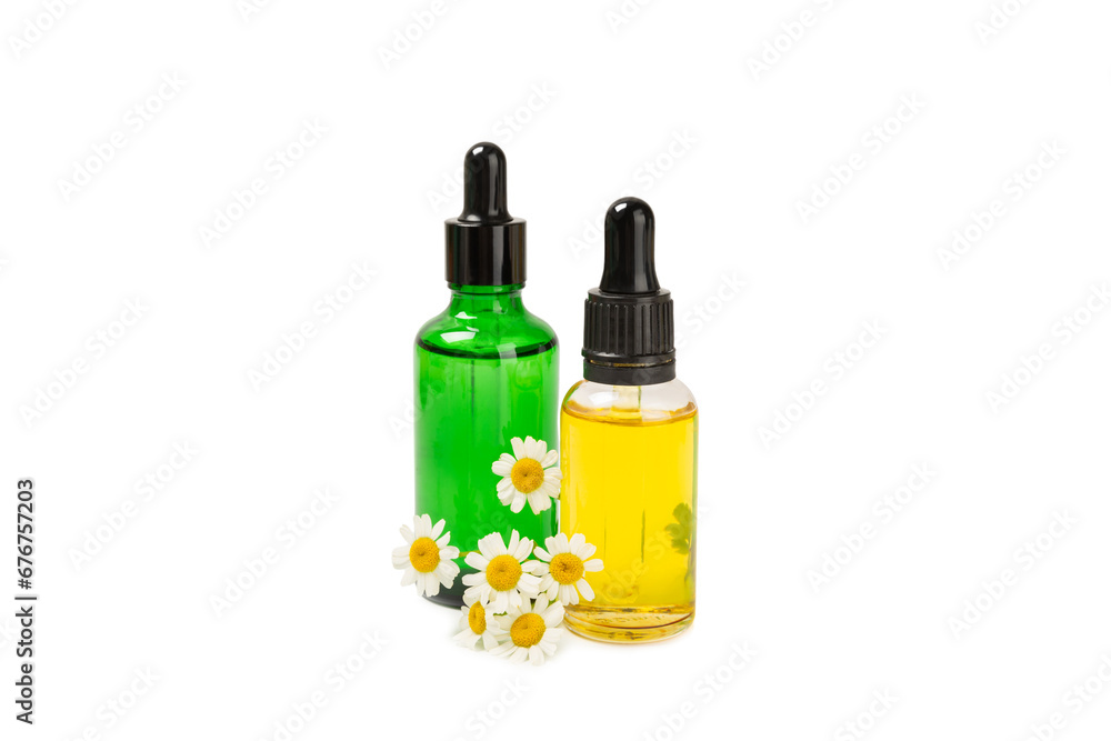 Glass bottle with chamomile essential oil isolated on white background. Chamomile flowers, close up. Aromatherapy, spa and herbal medicine ingredients. Beauty concept. Natural cosmetics Glass bottle with chamomile essential oil isolated on white background. Chamomile flowers, close up. Aromatherapy, spa and herbal medicine ingredients. Beauty concept. Natural cosmetics