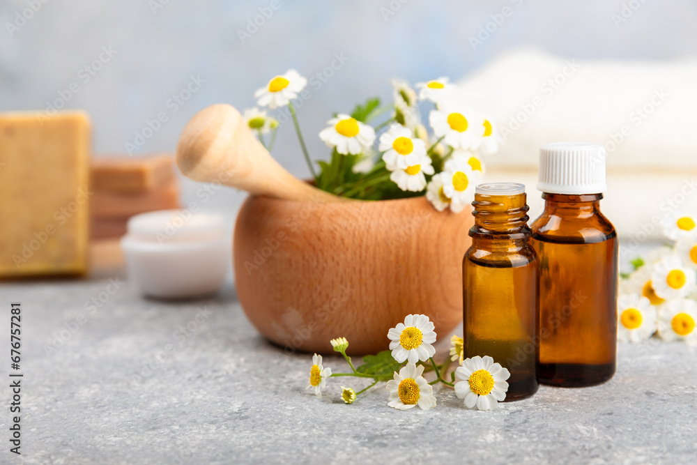 Glass bottle with chamomile essential oil on an old wooden background. Chamomile flowers, close up. Aromatherapy, spa and herbal medicine ingredients. Beauty concept.Copy space. Natural cosmetic Glass bottle with chamomile essential oil on an old wooden background. Chamomile flowers, close up. Aromatherapy, spa and herbal medicine ingredients. Beauty concept.Copy space. Natural cosmetic