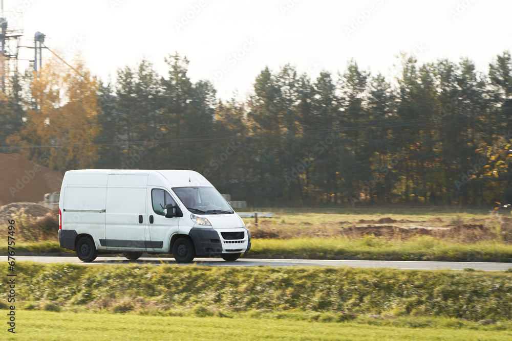 Fast-Moving White Delivery Van on Urban Highway. Distribution and Logistics in Action. Modern Delivery Van on the Road. Shipping and distribution concept. Fast-Moving White Delivery Van on Urban Highway. Distribution and Logistics in Action. Modern Delivery Van on the Road. Shipping and distribution concept.