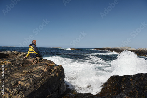 Mann sitzt an der Atlantikküste in Norwegen  © dieter76