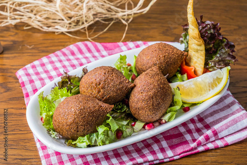 A plate of oriental fried kibbeh on a wooden floor