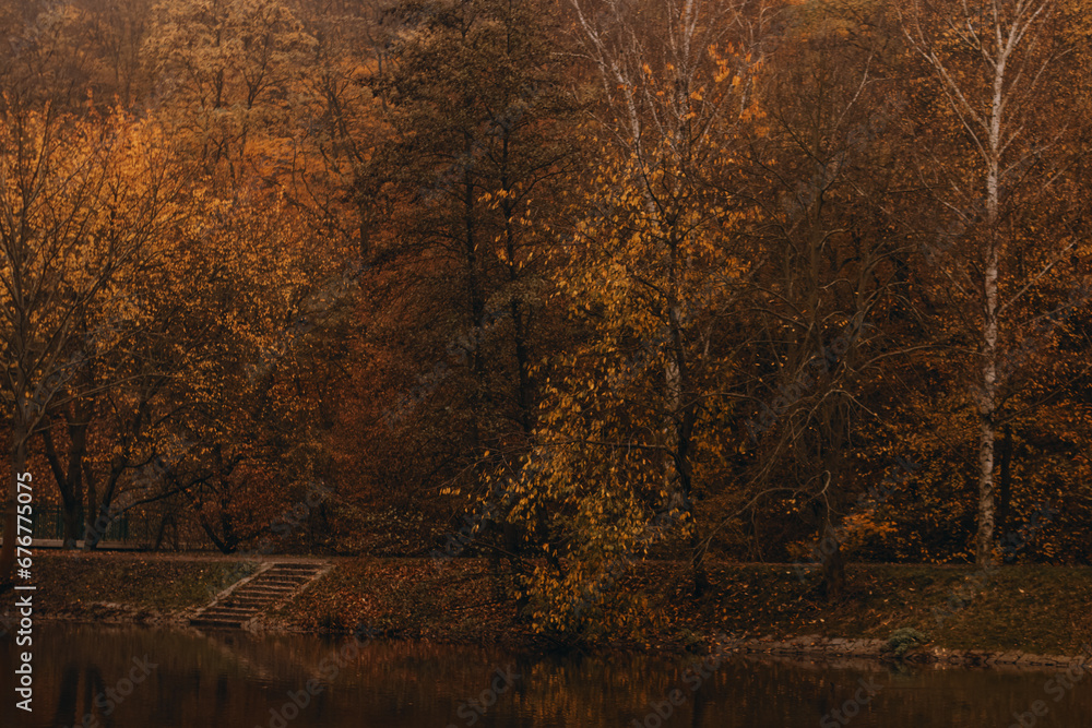 Calm evening on the lake, clear calm water, trees with autumn foliage and their reflection in the water, beautiful autumn landscape Calm evening on the lake, clear calm water, trees with autumn foliage and their reflection in the water, beautiful autumn landscape