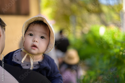 Baby girl in a garden looking into a camera