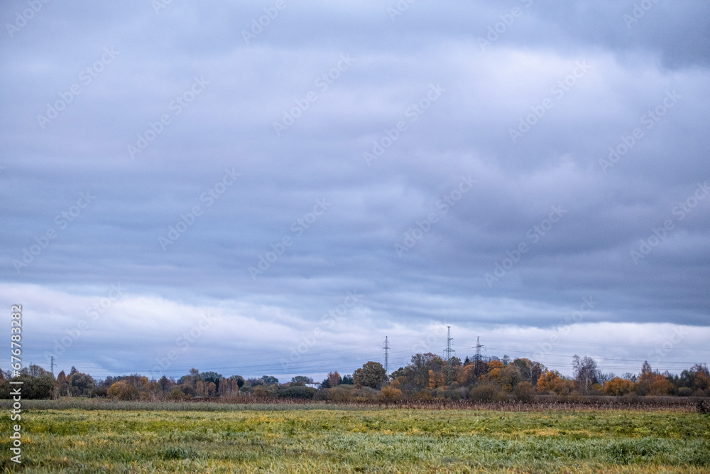 cloudy sky, meadow field, electric pylons far away