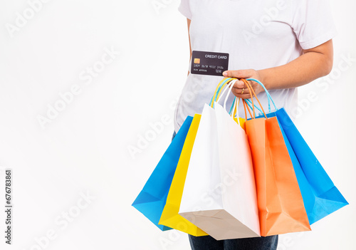 Happy woman hand holding shopping bags multicolor and credit card for shopping online, young female hold many packets within arms isolated on white background, Black Friday sale concept