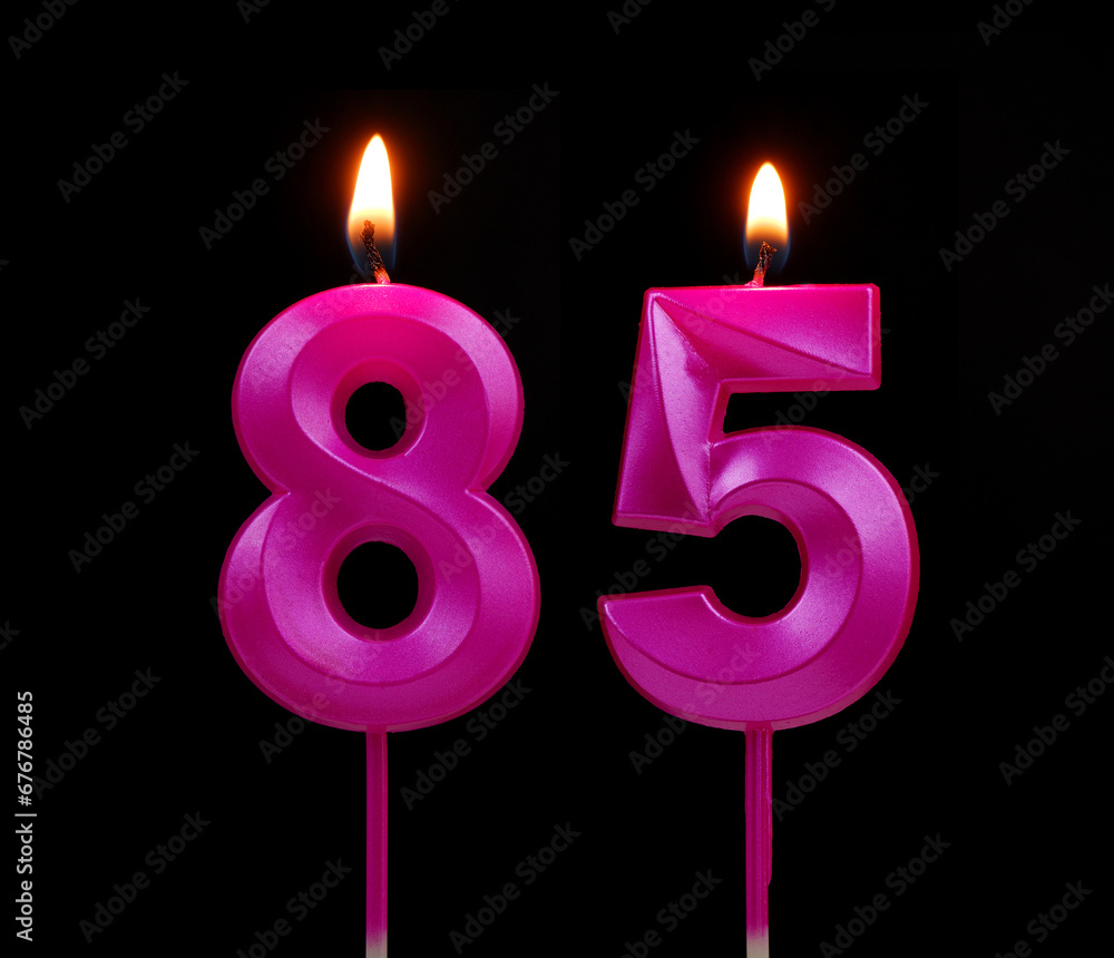 Burning pink birthday candles isolated on black background, number 85. Burning pink birthday candles isolated on black background, number 85.