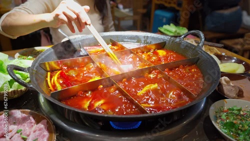 Female tourist eating original mala spicy hot pot in Chongqing, China