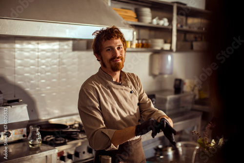 Chef putting on gloves preparing to cook in restaurant kitchen photo