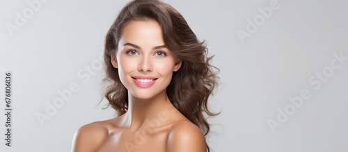 A young beautiful adult woman is seen as a sexy model on a white background representing the isolated pursuit of fitness health and beauty in sports while maintaining a focus on skin care an