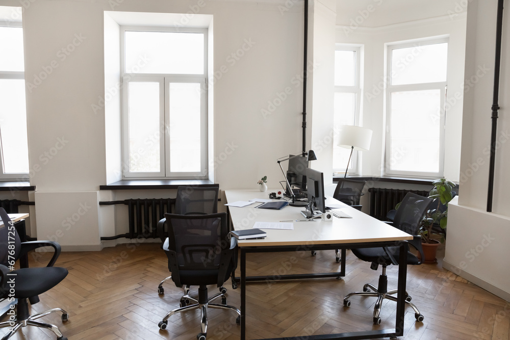 Empty modern office room with no people. Small workspace with desks, chairs, desktops, windows. Commercial property, real estate for rent with business interior