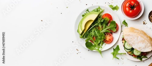 A healthy breakfast option is a veggie sandwich with a white background showcasing a top view of a plate filled with a green salad tomato slices and bread perfect for a nutritious diet