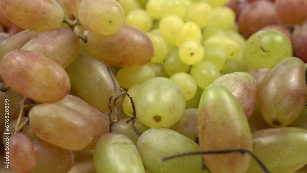 Large bunches of ripe grape of various varieties lies on a table, background, slow motion Large bunches of ripe grape of various varieties lies on a table, background, slow motion