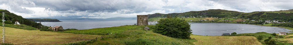 Uig bay panorama, with the Uig Tower, a 19th century folly. and the village beyond. Isle of Skye, Highlands of Scotland.