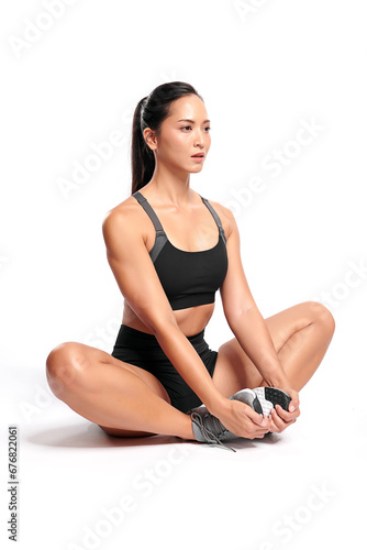 an asian woman is working out wearing the sport exercise suit with white background.