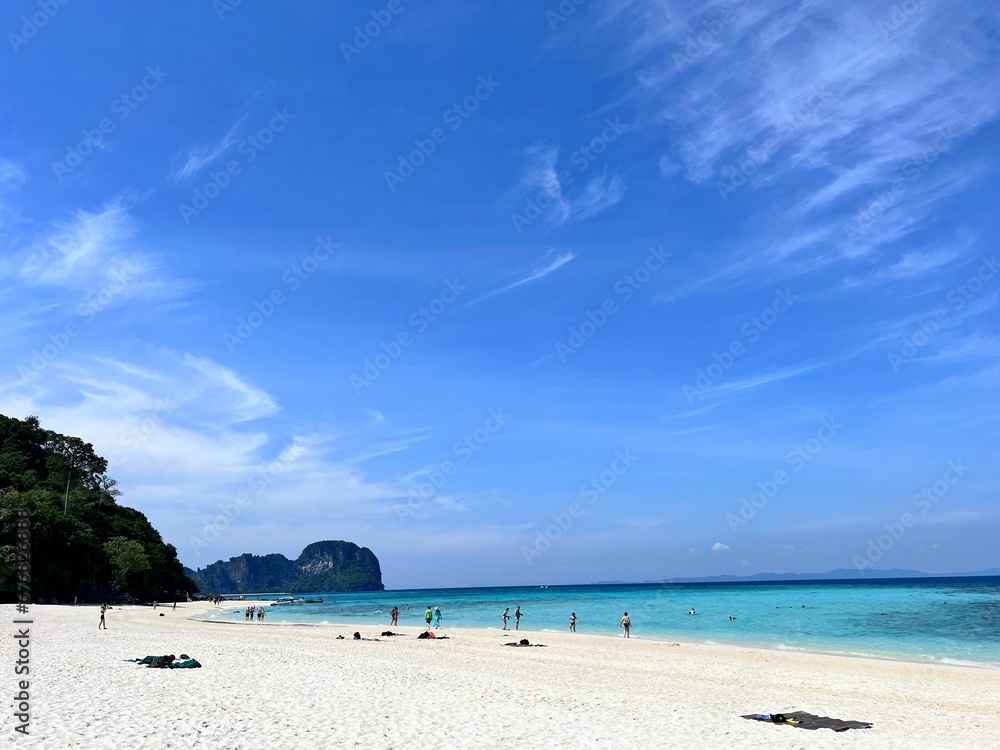Image of the beach full of people under the blue sky.