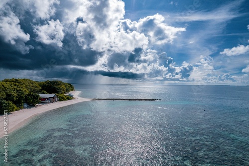 Aerial shot of the beautiful ocean and the Baa Kamadhoo beach in Maldives on a sunny day