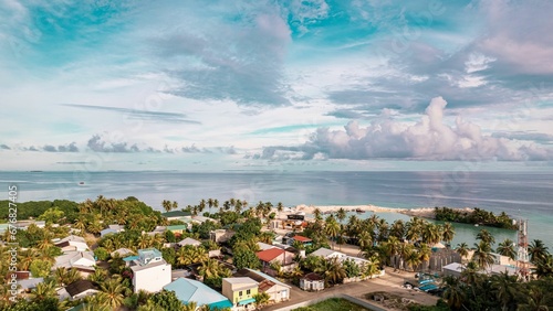 Photos Bird's eye view of a residential district with palm trees by a beach in Baa Kama