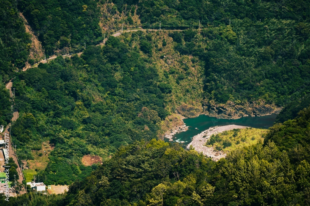 the view from a cliff near the water below and trees the view from a cliff near the water below and trees