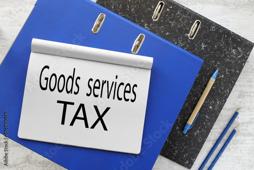 Wallpaper Mural GST (Abbreviation of Goods and Service Tax) two folders on the table, a blue folder and a black folder. text on a notepad. notebook on a folder Torontodigital.ca