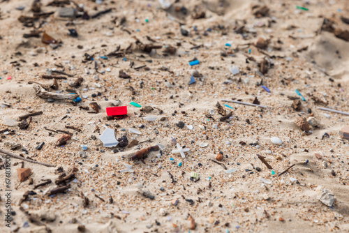 Plastic trash in sand on beach. Pollution by microplastic rubbish on coastline