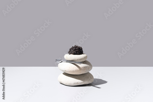 Caviar de esturión sobre piedras blancas. Comida gourmet sobre fondo gris 
