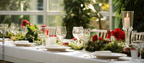 In the background of a beautifully designed space adorned with lush green plants and highlighted by soft winter light a white table is set filled with delicious food that radiates the color