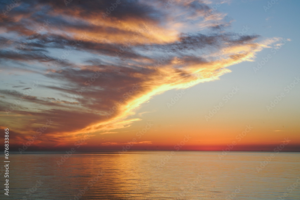 Fototapeta premium orange cloudy sunset sky view from the sea