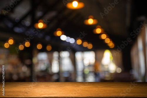 image of wooden table in front of abstract blurred background of resturant lights . High quality photo