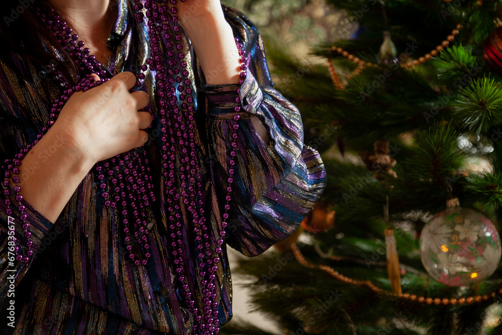 Hands hang garland on Christmas tree close up..