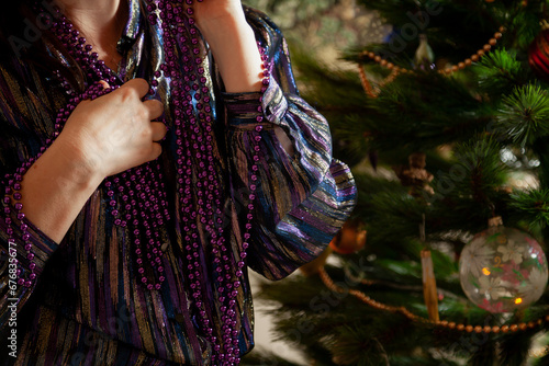 Hands hang garland on Christmas tree close up..