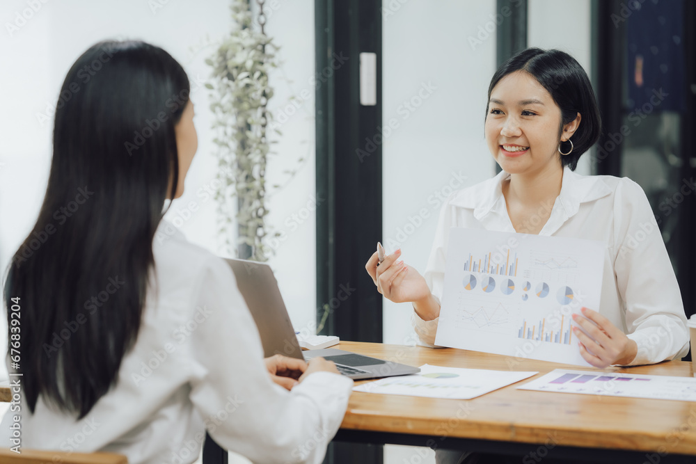 Group of confident business people point to graphs and charts to analyze market data, balance sheet, account, net profit to plan new sales strategies to increase production capacity. Group of confident business people point to graphs and charts to analyze market data, balance sheet, account, net profit to plan new sales strategies to increase production capacity.